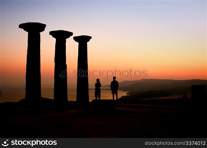 At an archeological site, two people watching the sunset