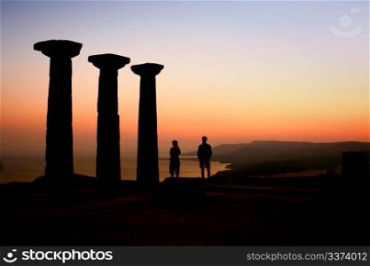 At an archeological site, two people watching the sunset