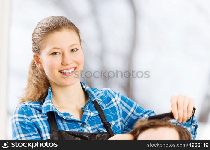 At beauty salon. Young man in chair at barbers and woman hairdresser