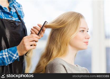 At beauty salon. Young woman in chair at barbers and hairdresser
