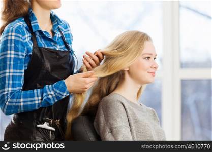 At beauty salon. Young woman in chair at barbers and hairdresser