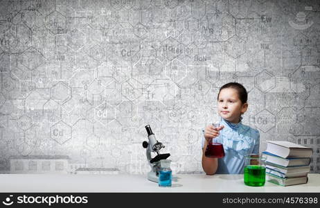 At chemistry lesson. Cute school girl at chemistry lesson with test tube