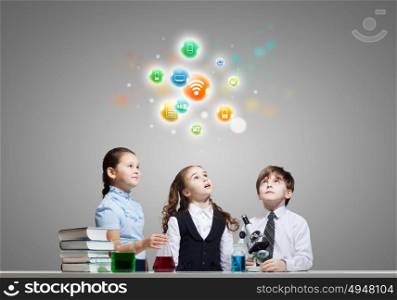 At chemistry lesson. Three cute children at chemistry lesson making experiments
