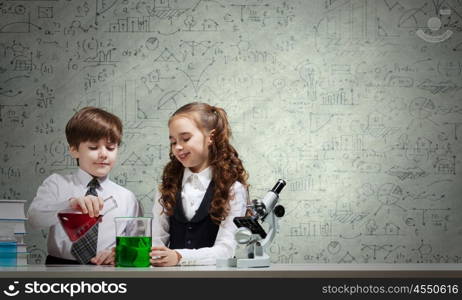 At chemistry lesson. Two cute children at chemistry lesson making experiments