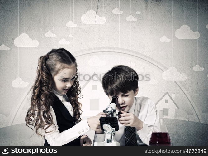 At chemistry lesson. Two cute children at chemistry lesson making experiments