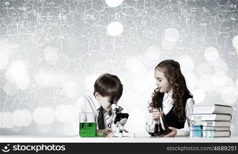 At chemistry lesson. Two cute children at chemistry lesson making experiments