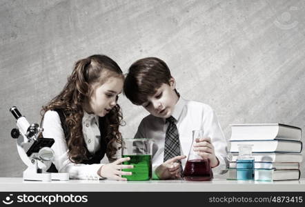 At chemistry lesson. Two cute children at chemistry lesson making experiments