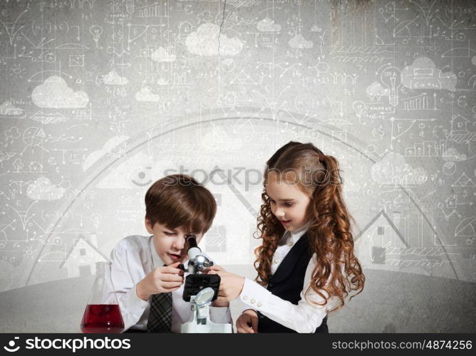 At chemistry lesson. Two cute children at chemistry lesson making experiments