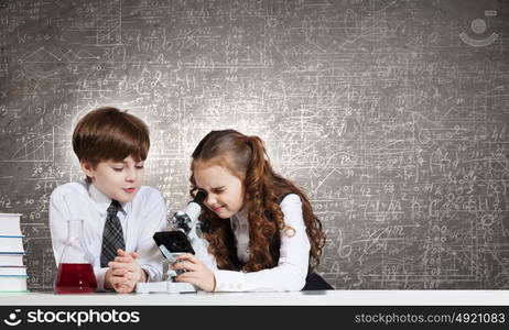 At chemistry lesson. Two cute children at chemistry lesson making experiments