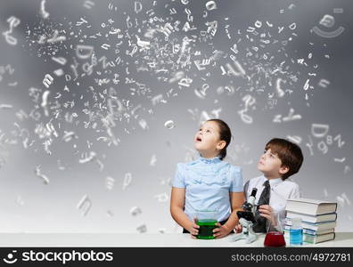 At chemistry lesson. Two cute children at chemistry lesson making experiments