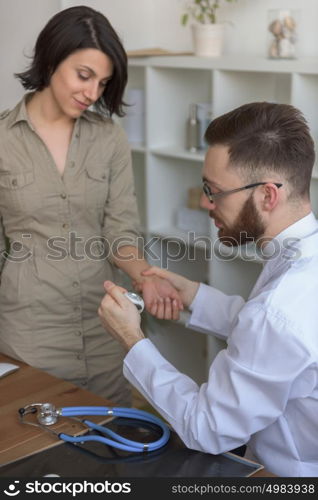 At doctor office. Doctor measuring patient pulse