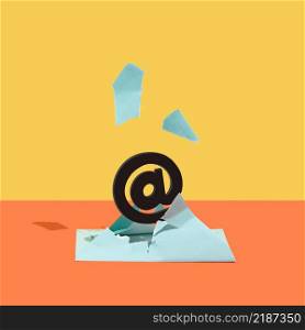 At, email sign, burst out of a blue envelope against orange and yellow background. Minimal concept. Square with copy space.. At, email sign, burst out of a blue envelope against orange and yellow background.