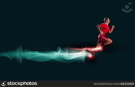 At full speed. Running man in red sport wear on green background