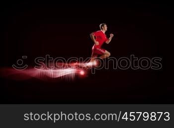 At full speed. Running man in red sport wear on red background