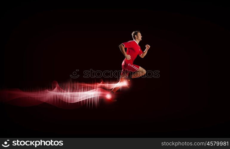 At full speed. Running man in red sport wear on red background