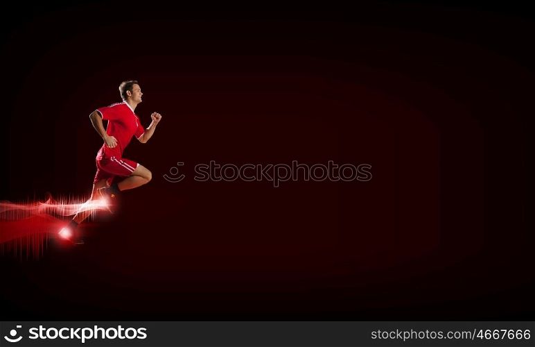 At full speed. Running man in red sport wear on red background