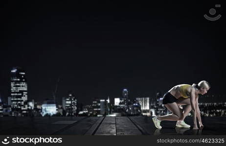 At full speed. Young woman athlete running fast on city background