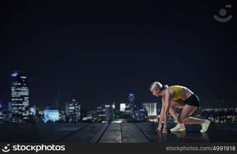 At full speed. Young woman athlete running fast on city background