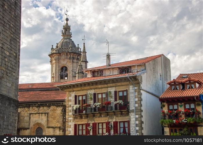 AT HONDARRIBIA, SPAIN - ON 08/28/2017 - colorful facades of houses and the tower bell of the cathedral in the historic center of Hondarribia, a basque country in the north of Spain