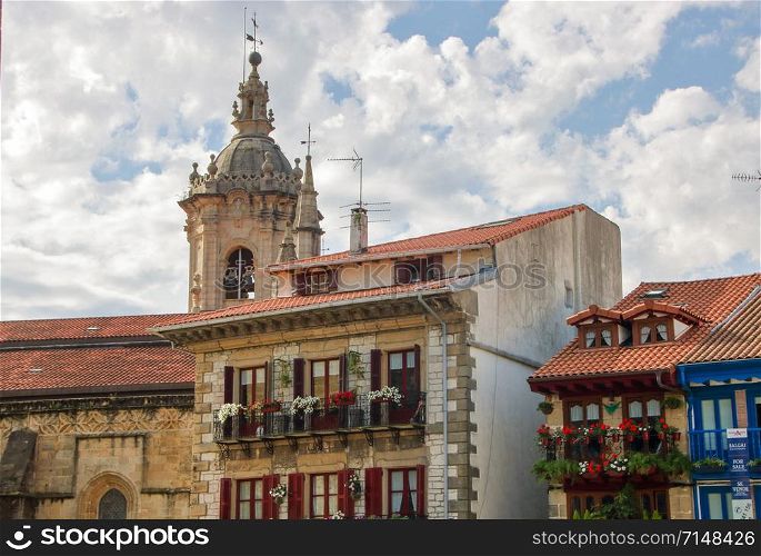 AT HONDARRIBIA, SPAIN - ON 08/28/2017 - colorful facades of houses and the tower bell of the cathedral in the historic center of Hondarribia, a basque country in the north of Spain