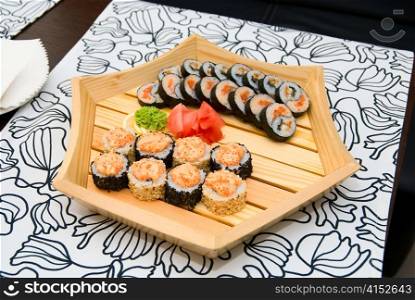 At restaurant: Set of sushi on wood plate.