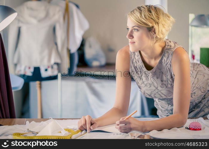 At tailors studio. Young woman dressmaker at tailors making measures