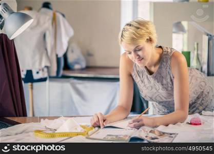At tailors studio. Young woman dressmaker at tailors making measures