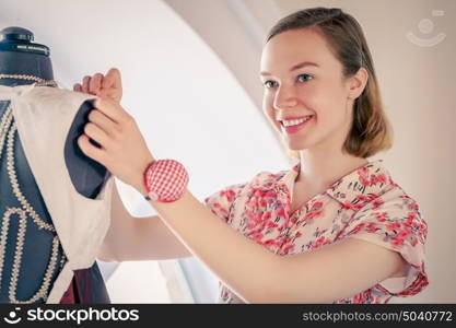 At tailors studio. Young woman dressmaker at tailors making measures