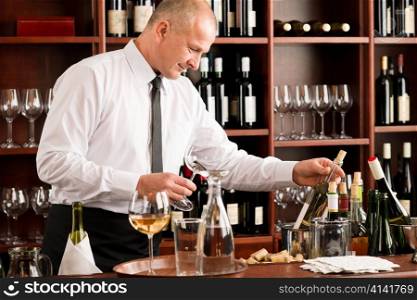 At the bar - waiter hold bottle white wine in restaurant