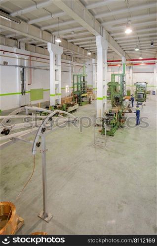 at the factory equipment for the deployment of copper tubes from rolls and cutting governed by workers. plant for the production of household air conditioners 