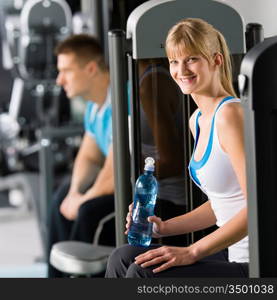 At the fitness center young woman relax on exercise machine