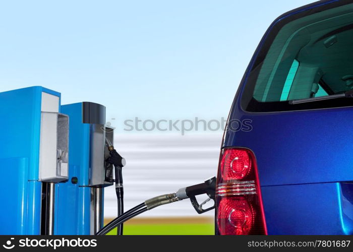 At the gas station pump putting gas into the car