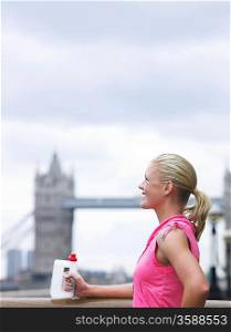 Athlete Drinking Bottled Water in Front of Tower Bridge