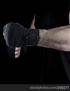 athlete is standing with a stretched arm bandaged, black background