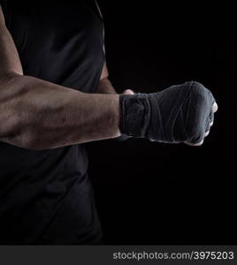 athlete is standing with a stretched arm bandaged, black background