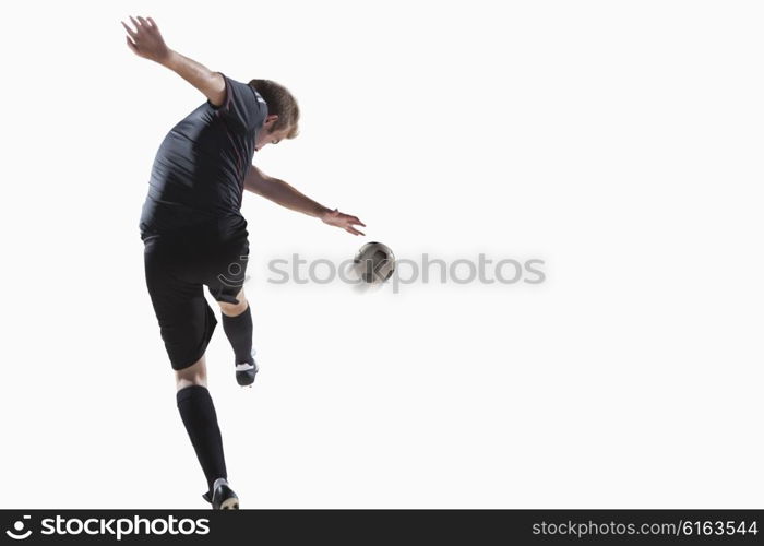 Athlete kicking soccer ball