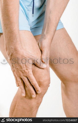 Athlete man feeling pain to the knee and the quadriceps. It could be Iliotibial band syndrome or quadriceps tendinopathy