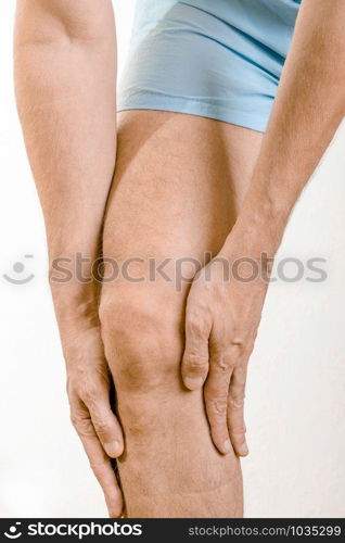 Athlete man massaging a painful soleus and gastrocnemius muscle, under the knee, after a sport accident. It could a musculaire claquage or a muscle elongation