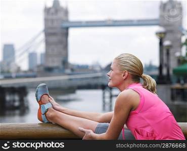 Athlete Stretching in Front of Tower Bridge