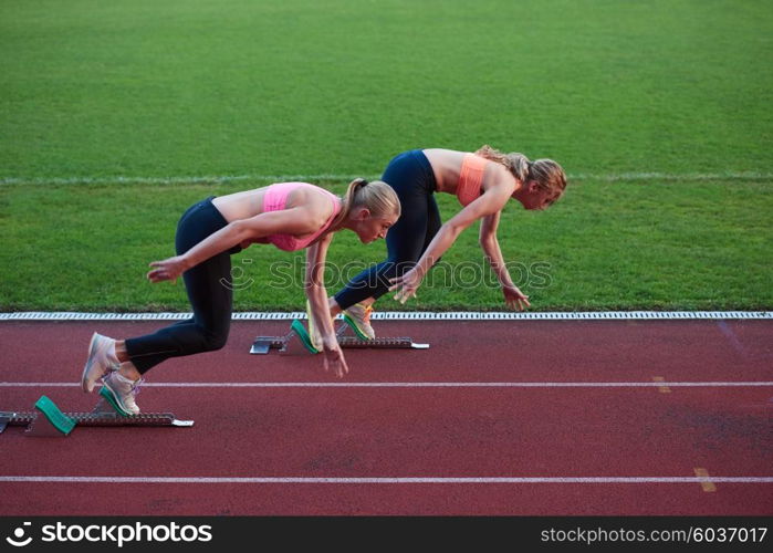 athlete woman group running on athletics race track on soccer stadium and representing competition and leadership concept in sport