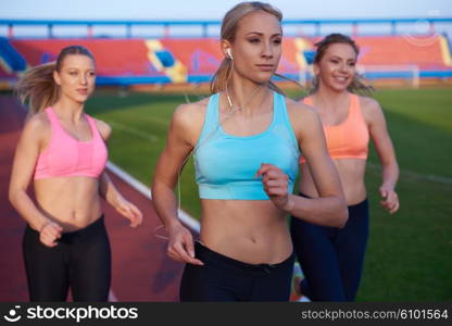 athlete woman group running on athletics race track on soccer stadium and representing competition and leadership concept in sport