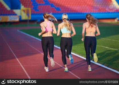 athlete woman group running on athletics race track on soccer stadium and representing competition and leadership concept in sport