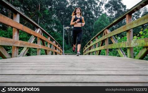 Athlete woman running through an urban park