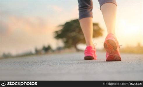 Athlete woman walking exercise on rural road in sunset background, healthy and lifestyle concept