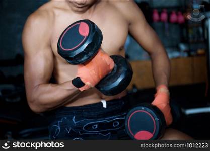 Athletes are lifting dumbbells to strengthen muscles in the gym.