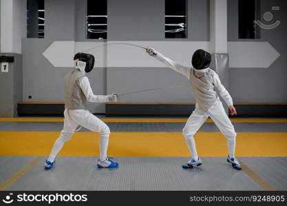 Athletes in uniforms and protective helmet mask fighting duel with rapiers. Swordsmanship competition concept. Martial art. Athletes in uniforms and protective helmet mask fighting duel with rapiers