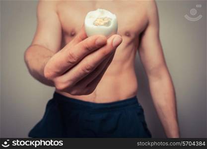 Athleti young man is holding a hard boiled egg