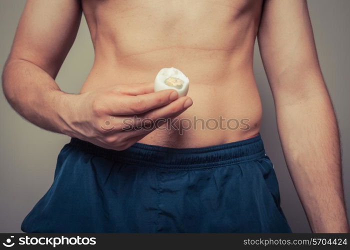 Athleti young man is holding a hard boiled egg