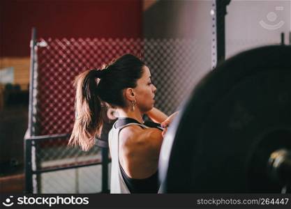 Athletic brunette young woman doing some weightlifting exercises