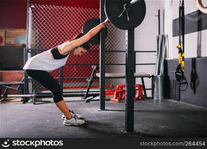 Athletic brunette young woman doing some weightlifting exercises
